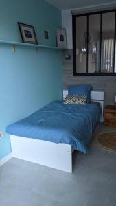 uma cama num quarto com uma parede azul em Royal Parc 7 em Mougins