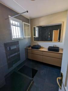 een badkamer met 2 blauwe wastafels en een spiegel bij Royal Parc 7 in Mougins
