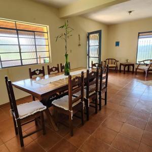 a dining room with a wooden table and chairs at Sítio Toca da Pedra in Pedra Bela