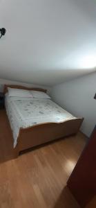 a bed in a room with a wooden floor at Old Town Baska in Baška