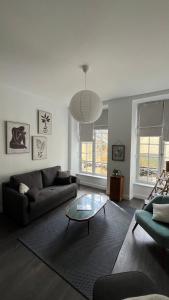 sala de estar con sofá y mesa de cristal en Appartement de charme en Bayeux