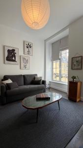 a living room with a couch and a glass table at Appartement de charme in Bayeux