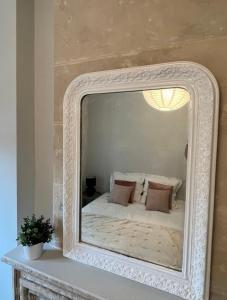 a mirror on a table with a bed in it at Appartement de charme in Bayeux