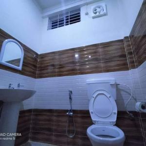 a bathroom with a toilet and a sink at MONIRAMS INN. in Kāziranga