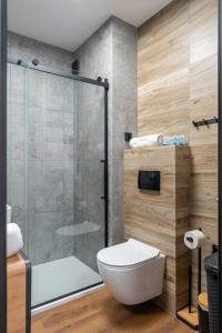 a bathroom with a toilet and a glass shower at Apartamenty w Karkonoszach- Apartament Lucky 7 z widokiem na Śnieżkę i ogródkiem in Karpacz