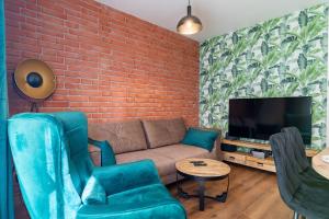 a living room with a couch and a brick wall at Apartamenty w Karkonoszach- Apartament Lucky 7 z widokiem na Śnieżkę i ogródkiem in Karpacz