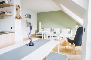 - un salon blanc avec un vase bleu sur une table dans l'établissement Design Apartment in Hallbergmoos, à Hallbergmoos