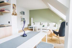 a white living room with a blue vase on a table at Design Apartment in Hallbergmoos in Hallbergmoos