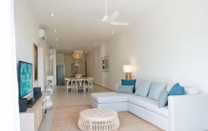 - un salon avec un canapé blanc et une télévision dans l'établissement Ocean Point Beachfront Residences - Apartment A1, à Pointe-aux-Piments
