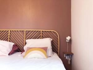 a bed with a wooden headboard and pillows at Le songe d'Etigny in Luchon