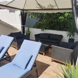 a patio with couches and chairs and an umbrella at Old Town Baska in Baška +37 photos