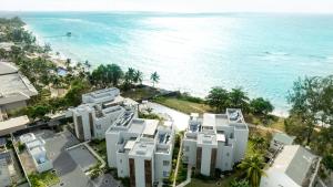 Ocean Point Beachfront Residences - Apartment A1 في بوينتي أو بيتشيز: اطلالة جوية على مباني بيضاء بجانب المحيط