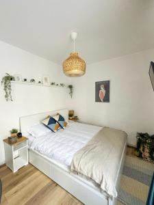 a bedroom with a white bed and a chandelier at Zen Studio in Braşov