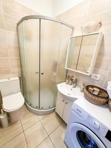 a bathroom with a shower and a washing machine at Zen Studio in Braşov +2 photos