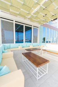 a living room with white furniture and a table at Tiffany Beach in Durat  Alarous