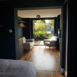 a bedroom with a door open to a living room at Recently extended garden apartment near JR and Oxford in Oxford