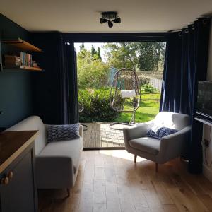 - un salon avec un canapé, une chaise et une fenêtre dans l'établissement Recently extended garden apartment near JR and Oxford, à Oxford