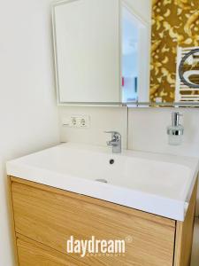 een badkamer met een witte wastafel en een spiegel bij Traumwohnung im Wissenschaftspark in Osnabrück