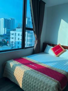 a bed in a room with a large window at Khách sạn An Phú Cửa Lò in Cửa Lò