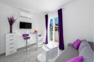 a white living room with a couch and a desk at Apartments Lana in Mlini
