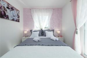 a bedroom with a large bed with two pillows at Apartments Lana in Mlini
