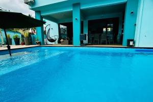 a large blue swimming pool in a house at Villa turquoise Exotique in Flic-en-Flac