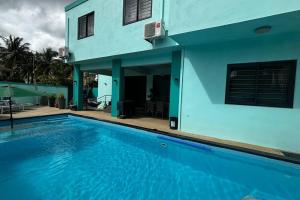 a house with a swimming pool in front of a house at Villa turquoise Exotique in Flic-en-Flac +25 photos