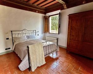 1 dormitorio con cama y ventana en Villa Mucellena, en Casole dʼElsa