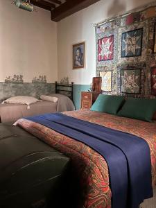 sypialnia z 2 łóżkami i ścianą ozdobioną obrazami w obiekcie La Spelonca degli Asini w mieście Prata