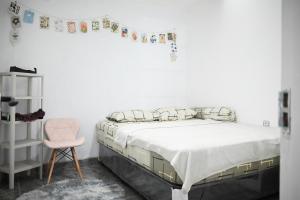 1 dormitorio con 1 cama y 1 silla rosa en Fanda Home Syariah en Cimanggu