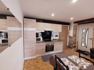 a kitchen with wooden walls and a table in a room at Gîte Corrézien 3 pers. Piscine chauffée in Chamboulive