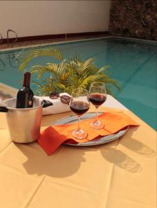 ネイバにあるHOTEL DINASTIA REAL NEIVAのスイミングプールの横のテーブルの上でワイン2杯