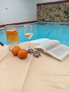 una mesa con una copa de vino y un libro en HOTEL DINASTIA REAL NEIVA, en Neiva