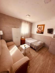 sala de estar con 2 camas y sofá en Apartamentos Murallas Merinies, en Ceuta