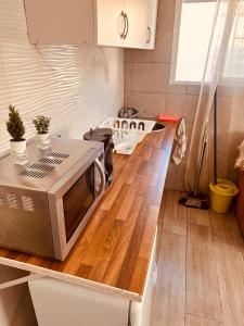 a kitchen with a microwave on top of a counter at Apartamentos Murallas Merinies in Ceuta