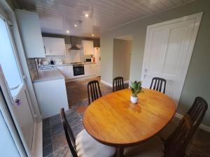 a dining room table with chairs and a kitchen at 3 bedroom sleeps 4 in Glenrothes in Fife