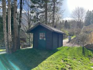 a small shed with a green door in a yard at Chalet Schäftal 