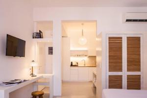 a white room with a desk and a kitchen at NESEA Boutique Apartments in Hydra