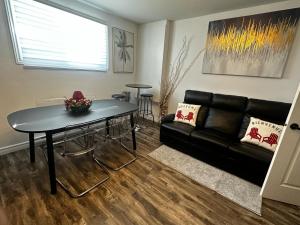 ein Wohnzimmer mit einem schwarzen Sofa und einem Tisch in der Unterkunft Refuge urbain à Beauport in Québec