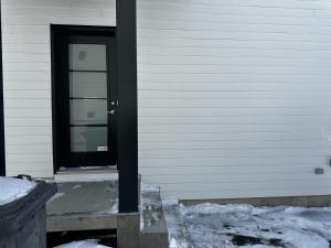 a black door on the side of a house at Refuge urbain à Beauport in Quebec City