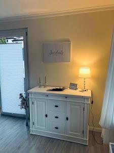 a room with a white dresser with a lamp on it at Maison Lily Apartment 4 in Bad Lauterberg