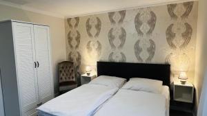 a bedroom with a bed with white sheets and two lamps at Maison Lily Apartment 4 in Bad Lauterberg