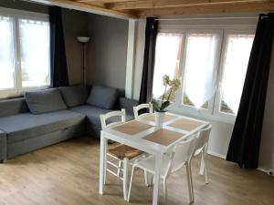 een woonkamer met een tafel en een bank bij Chalet Charmant Monika avec Piscine in Yvoir