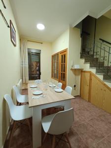 uma sala de jantar com uma mesa e cadeiras brancas em Plaça de l'Almudí, where else! em Onda