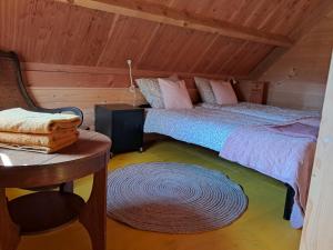 a bedroom with two beds and a table and a chair at Blokhut in Ruinerwold