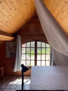 a bedroom with a bed and a large window at Las Vignes - Wo die Ruhe die Seele befriedet in Cazes-Mondenard
