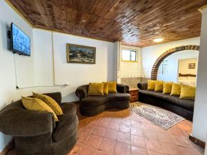 a living room with two couches and a tv at Mckay's Quinta in Yaruqui