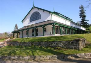 a large building on top of a grassy hill at The Retreat Hotel in Strathpeffer