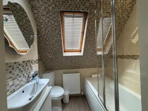 a bathroom with a sink and a toilet and a shower at Quirky cottage in the historical town of Beverley in Beverley