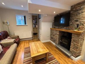 a living room with a stone fireplace and a tv at Quirky cottage in the historical town of Beverley in Beverley +5 photos